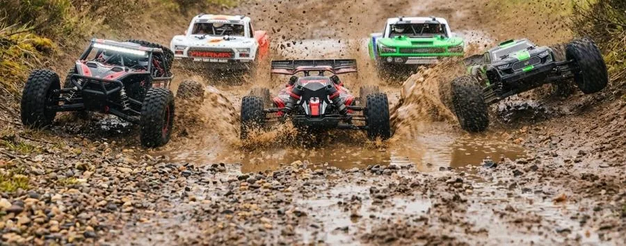 Des RC tout terrain dans une flaque de boue, projections d'eau